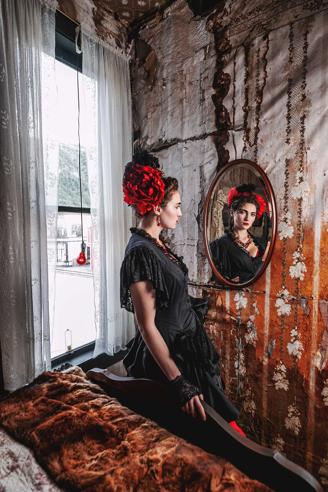Madam in period dress in the preserved brothel room